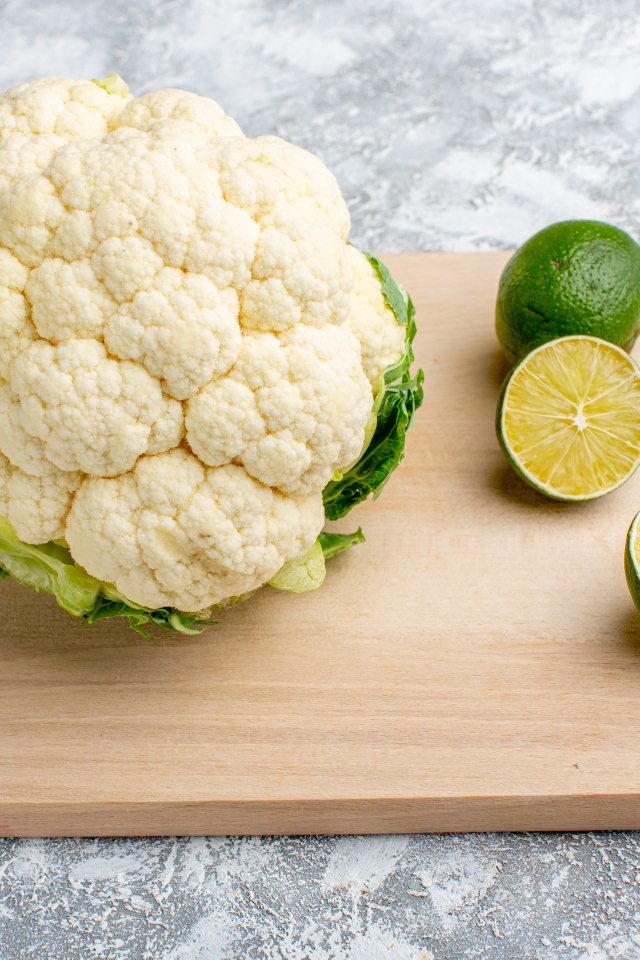 Цветная капуста с кусочками лайма на доске