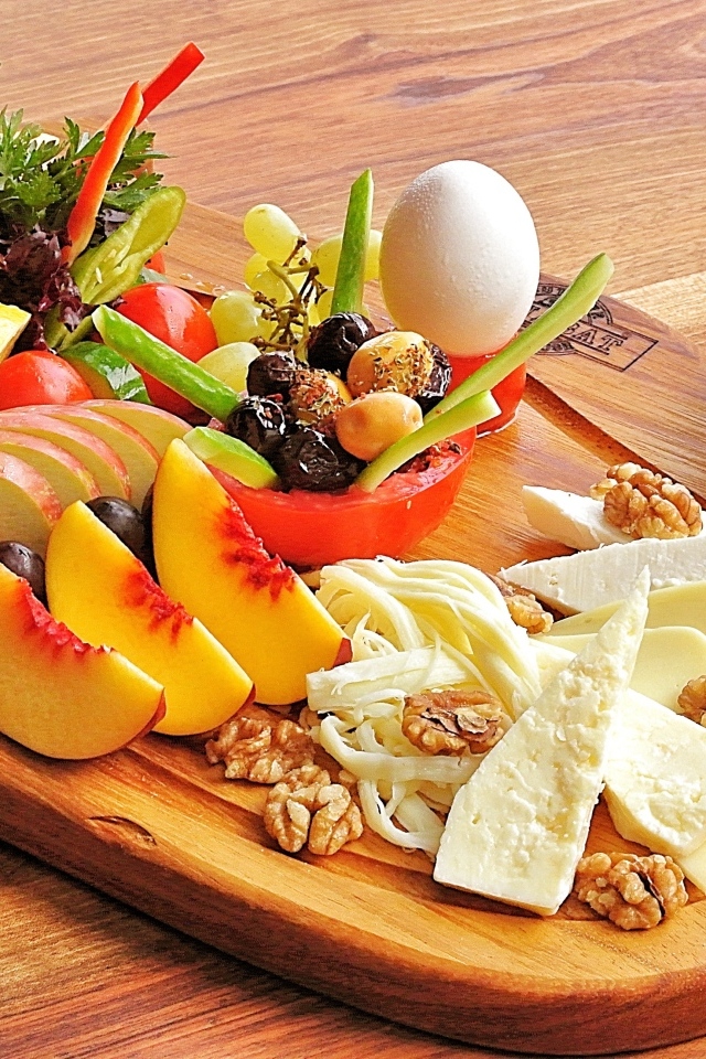 Сыр на доске с фруктами и салатом
