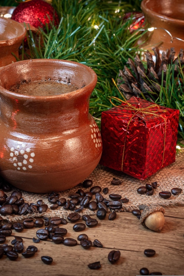 Кофейные зерна на столе с посудой и еловой веткой