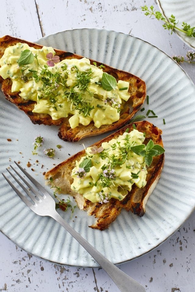 Гренки с кремом и зеленью на тарелке