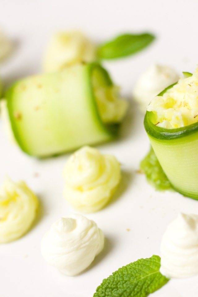 Рулетики из огурца с кремом на белом фоне