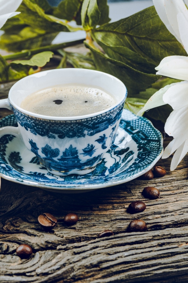 Чашка кофе с макарунами на столе с цветами