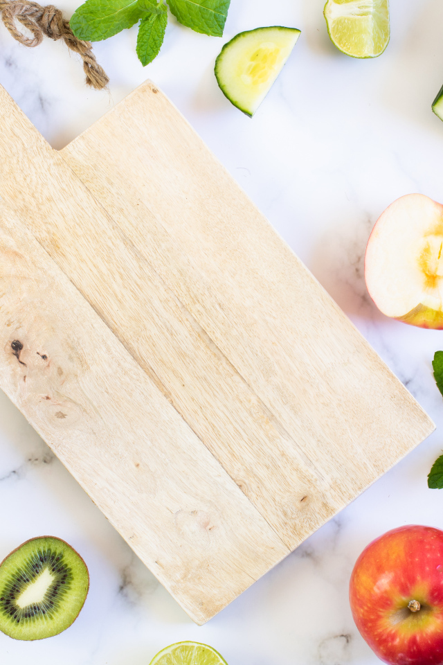 Разделочная доска с фруктами и овощами на столе