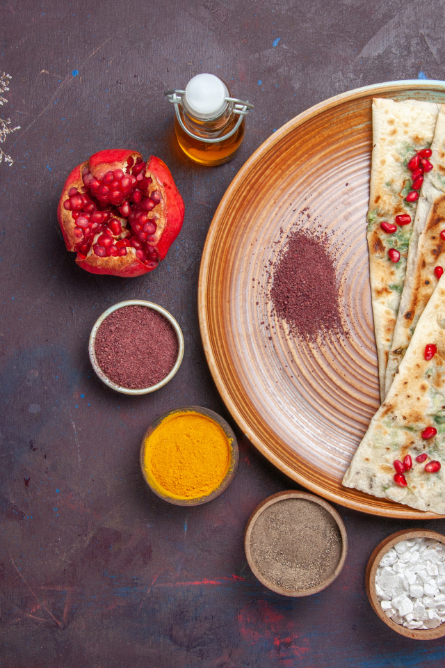 Лепешки на столе со специями и зеленью