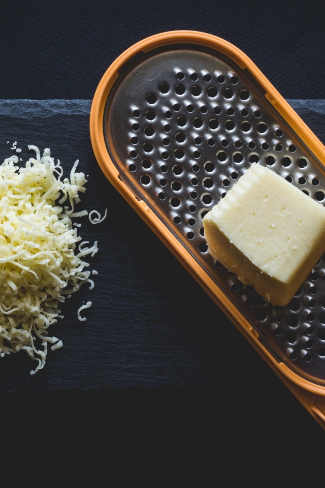 Тертый сыр на черном столе