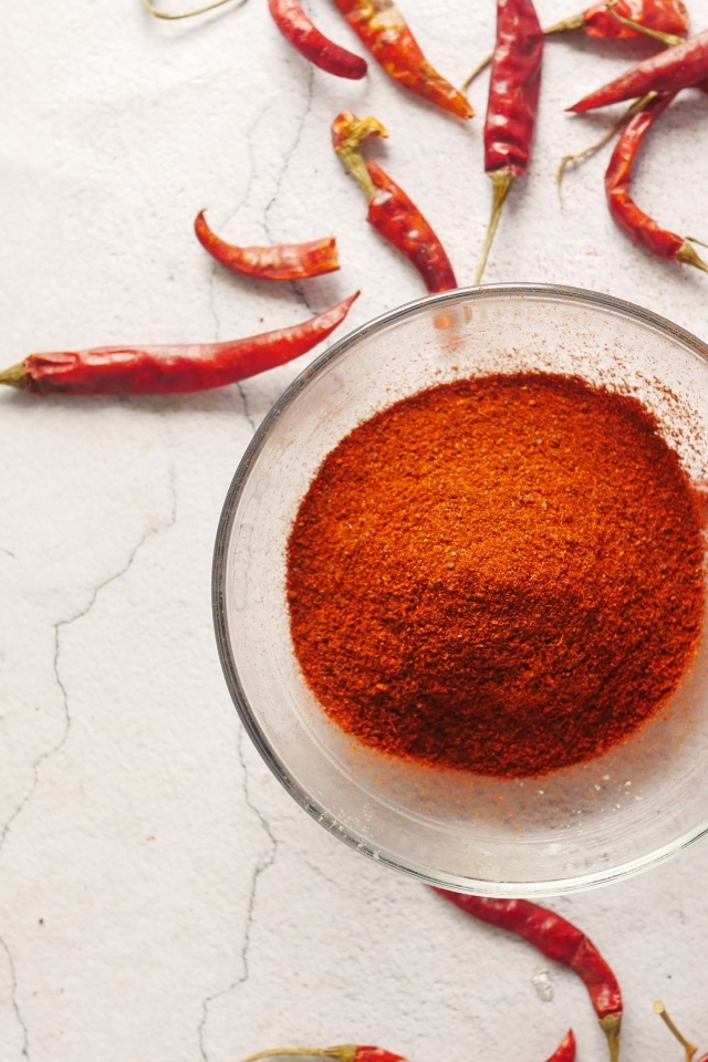 Молотый жгучий красный перец на столе