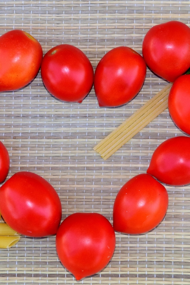 Сердце из помидоров на столе с макаронами