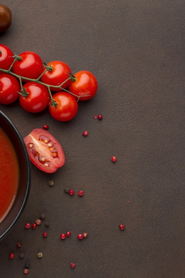 Кетчуп в тарелке на столе с помидорами