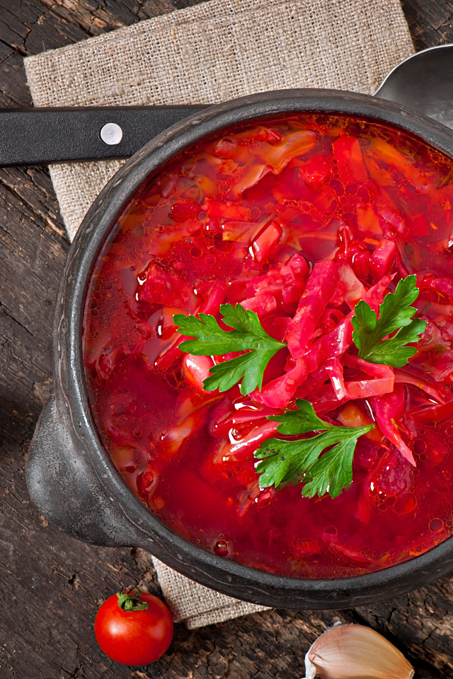 Большая тарелка красного борща на столе