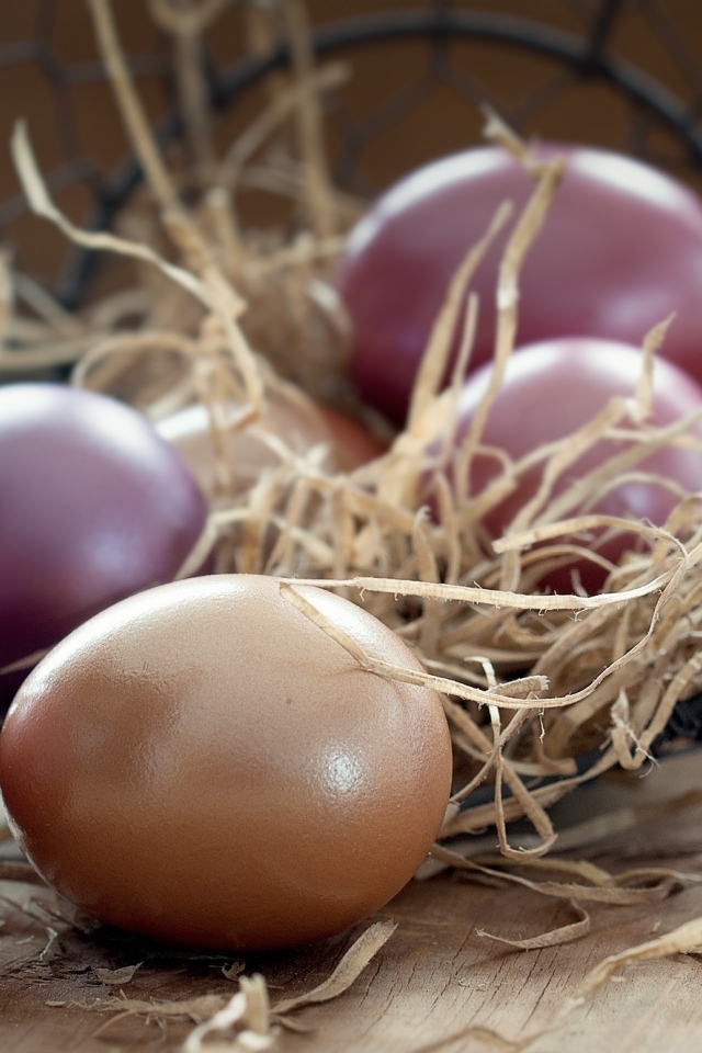 Разноцветные яйца на столе с сеном