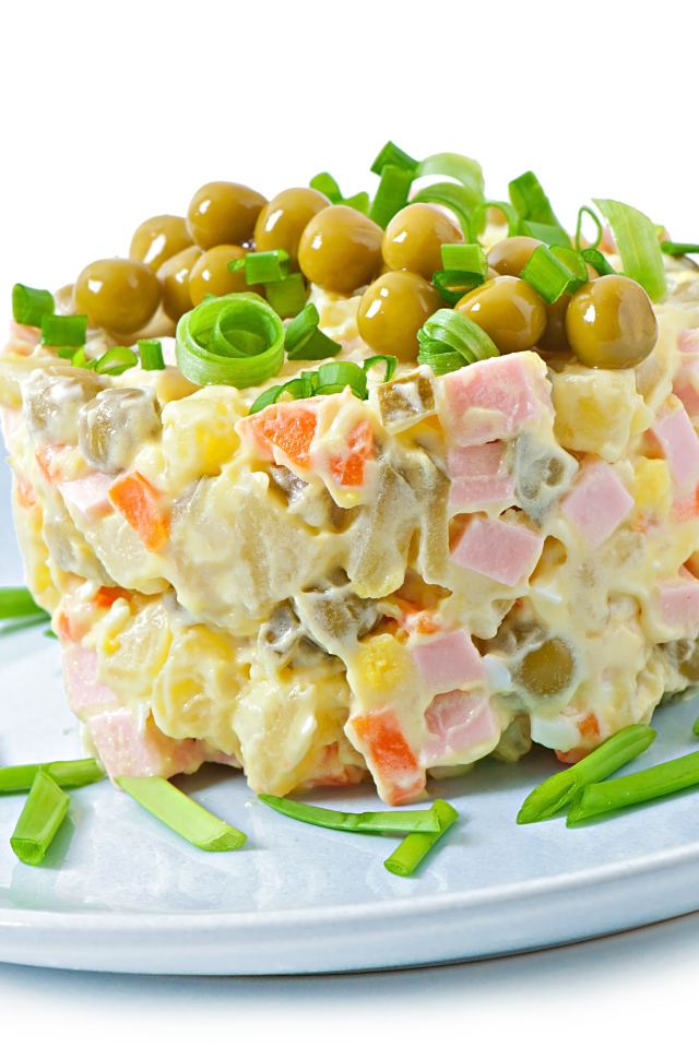 Салат оливье с зеленым горошком на тарелке 