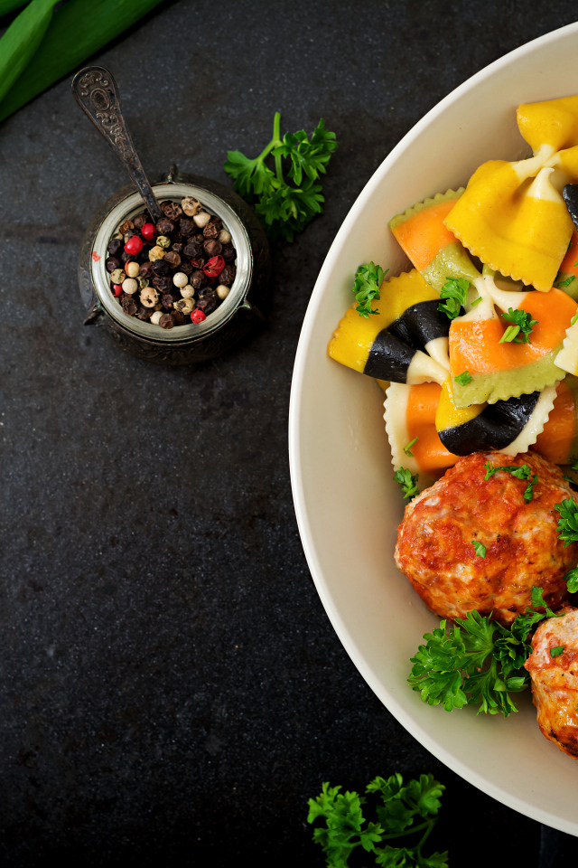 Паста с тефтелями и салатом в тарелке