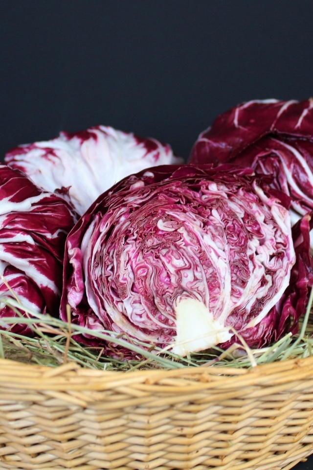 Красная капуста в корзине на черном фоне