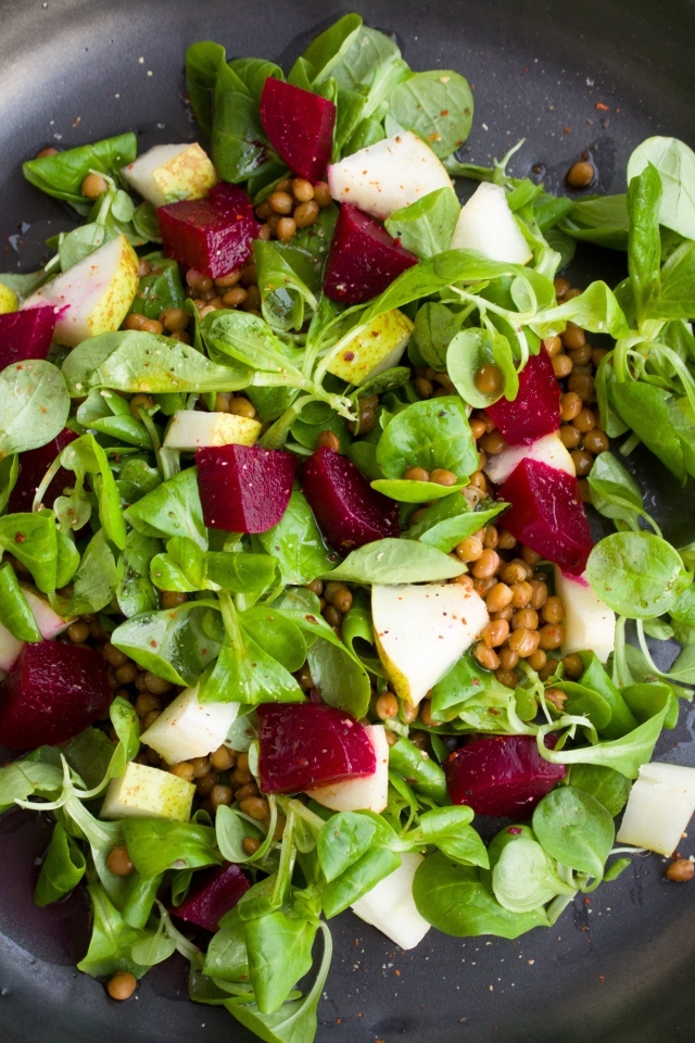 Салат с зеленью в большой черной тарелке