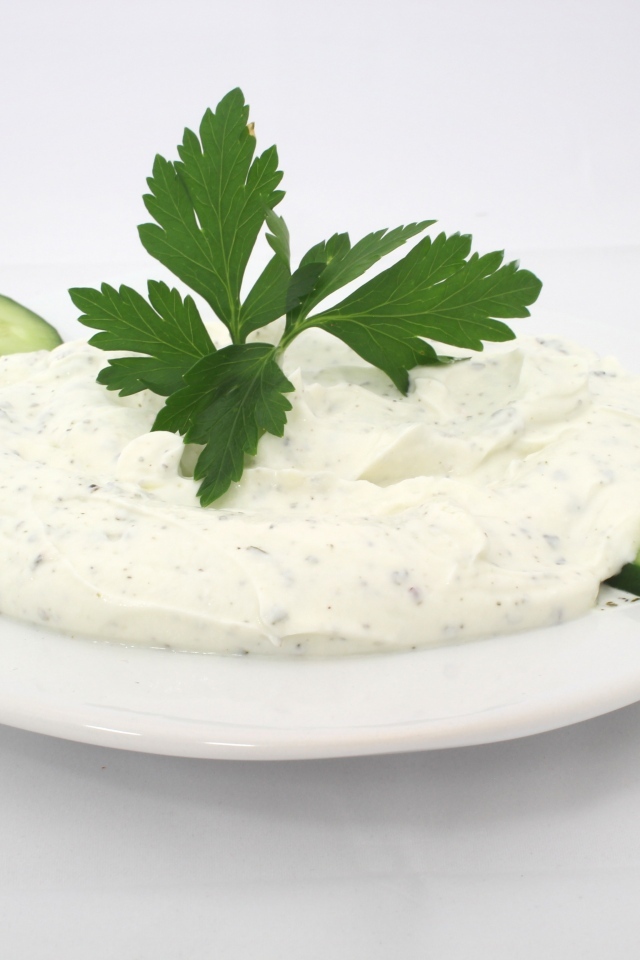 Соус на тарелке со свежими огурцами