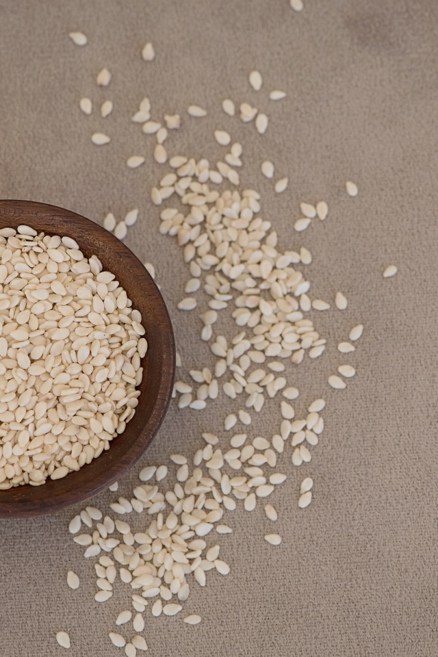 Зерна кунжута в деревянной миске на столе