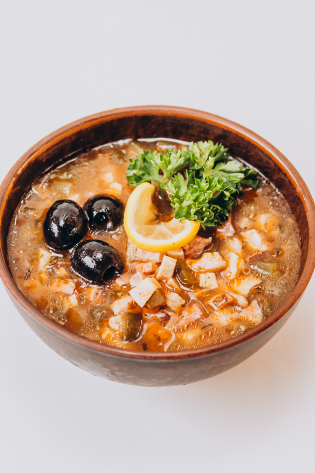 Солянка в тарелке на сером фоне