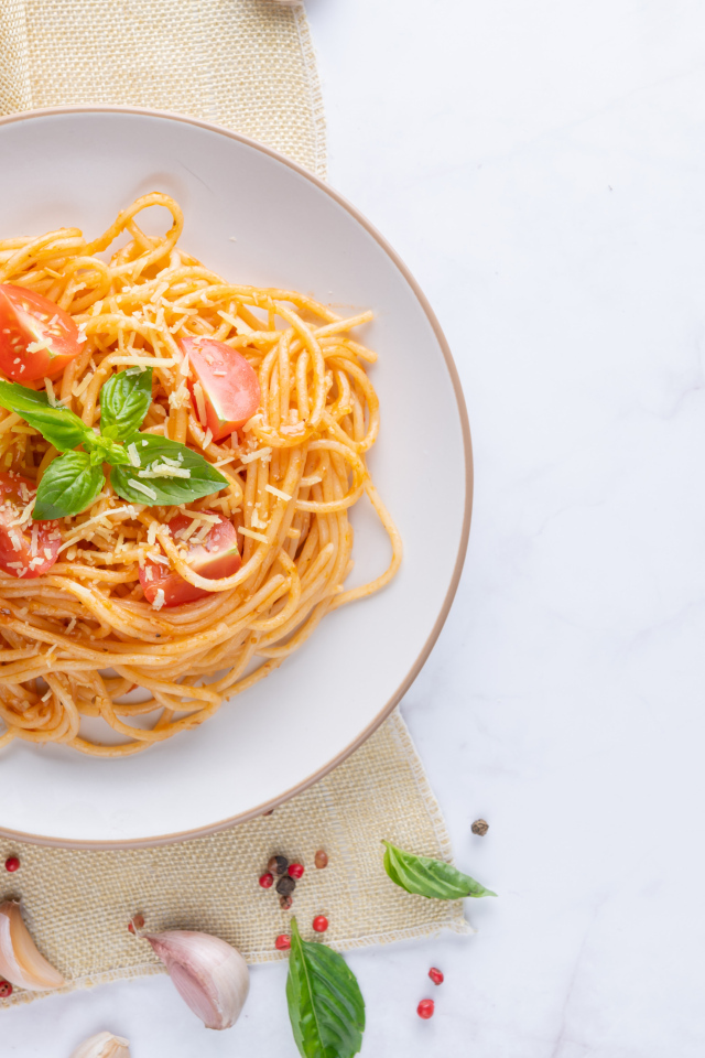 Spaghetti with tomatoes in a plate on the table