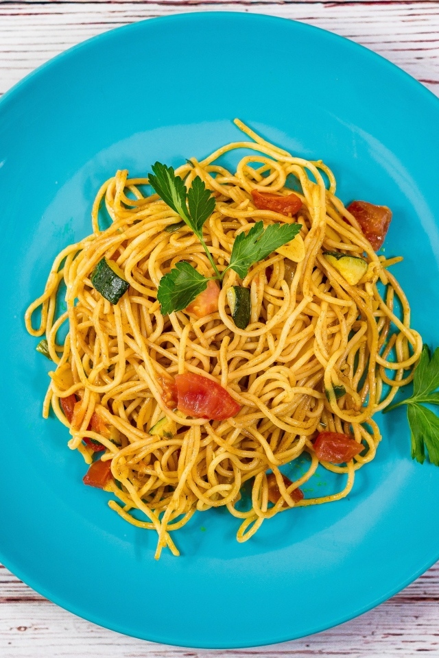 Спагетти с овощами  на голубой тарелке