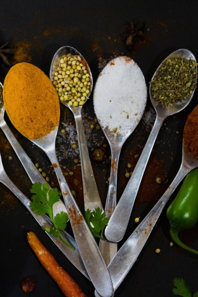 Ложки с ароматными специями на черном столе