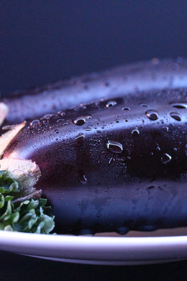 Два баклажана на тарелке с зеленью