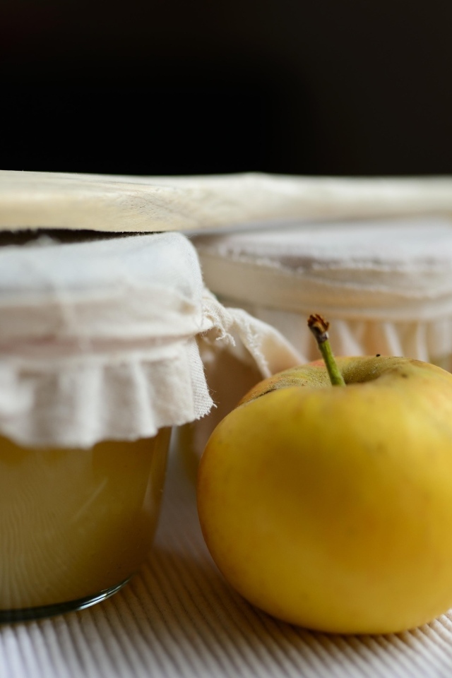 Яблочное пюре в банке на столе с плодами