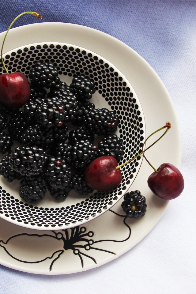 Ягоды ежевики и черешни на столе