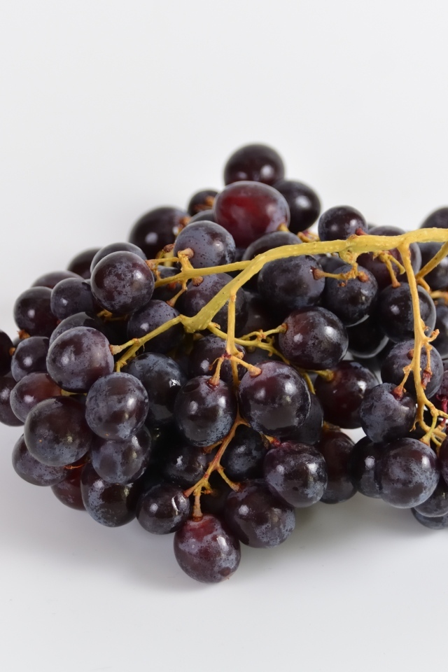 Гроздь розового винограда на сером фоне