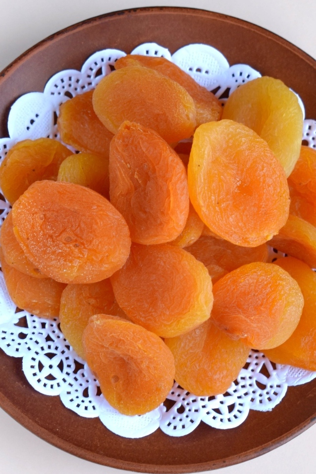 Курага с тарелке на сером фоне