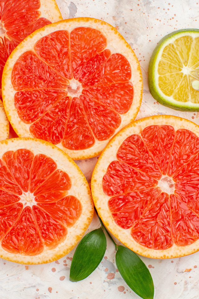 Грейпфрут и лимон нарезанные кусочками на столе