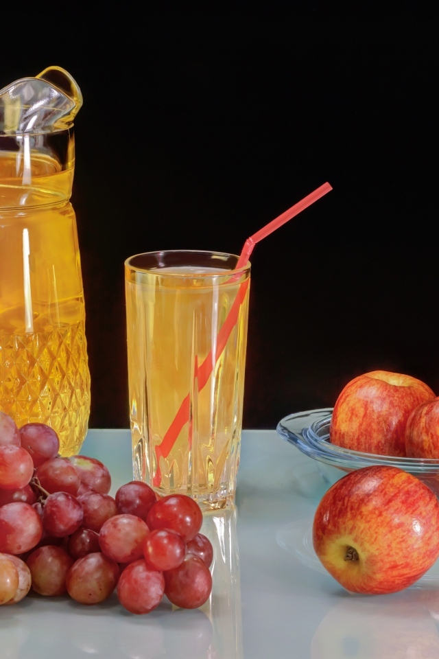 Виноград и яблоки на столе с соком