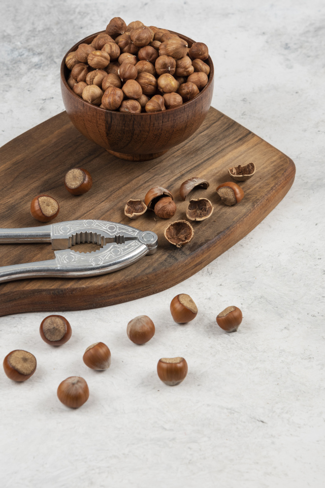 Лесные орехи на сером столе с разделочной доской