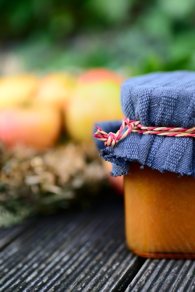 Банка яблочного джема на столе крупным планом