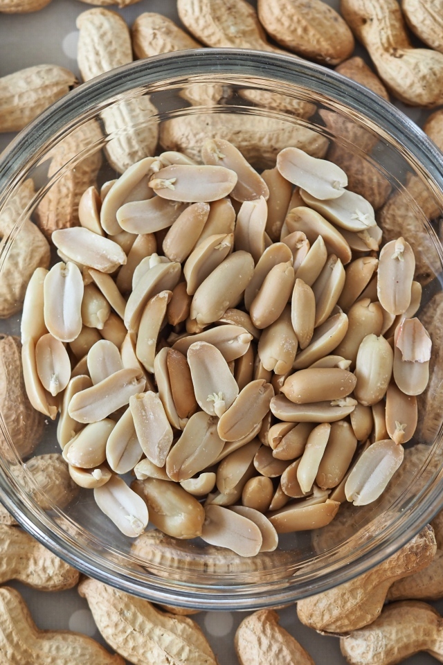 Арахис в стеклянной тарелке на столе 