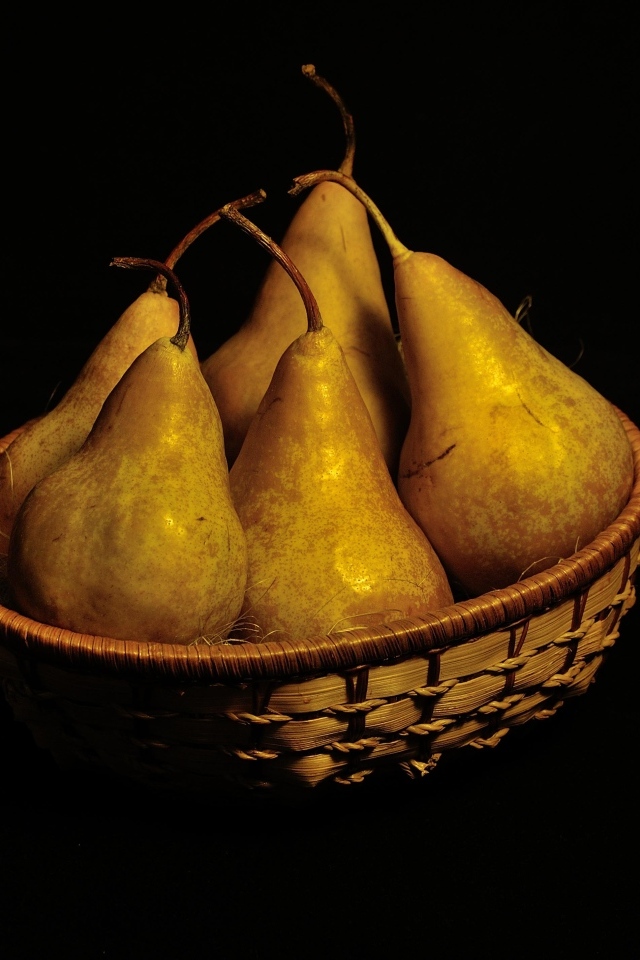 Груши в корзине на черном фоне