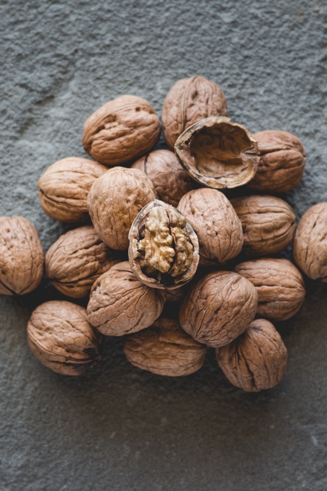 Куча грецких орехов на сером столе