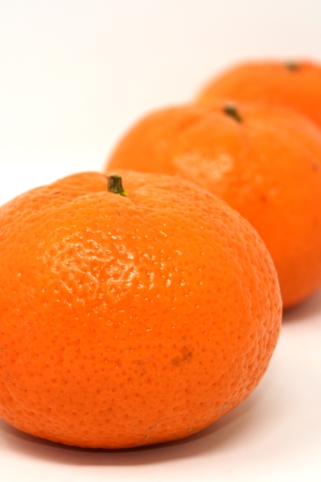 Три больших спелых мандарина на столе