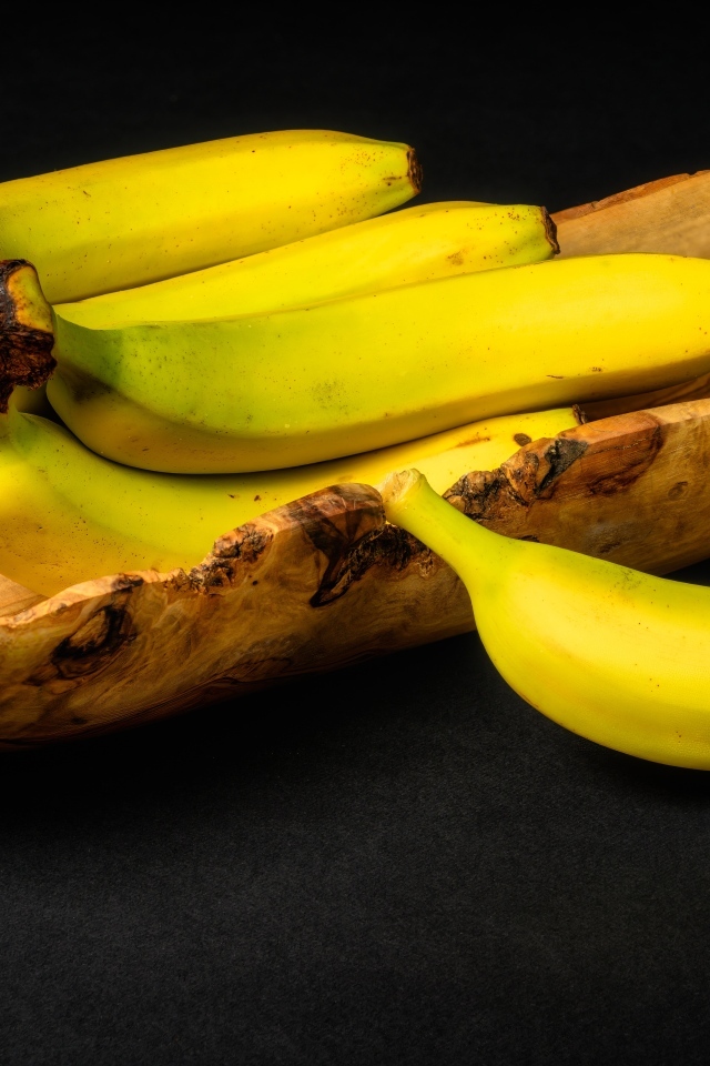 Деревянная чаша с бананами на столе