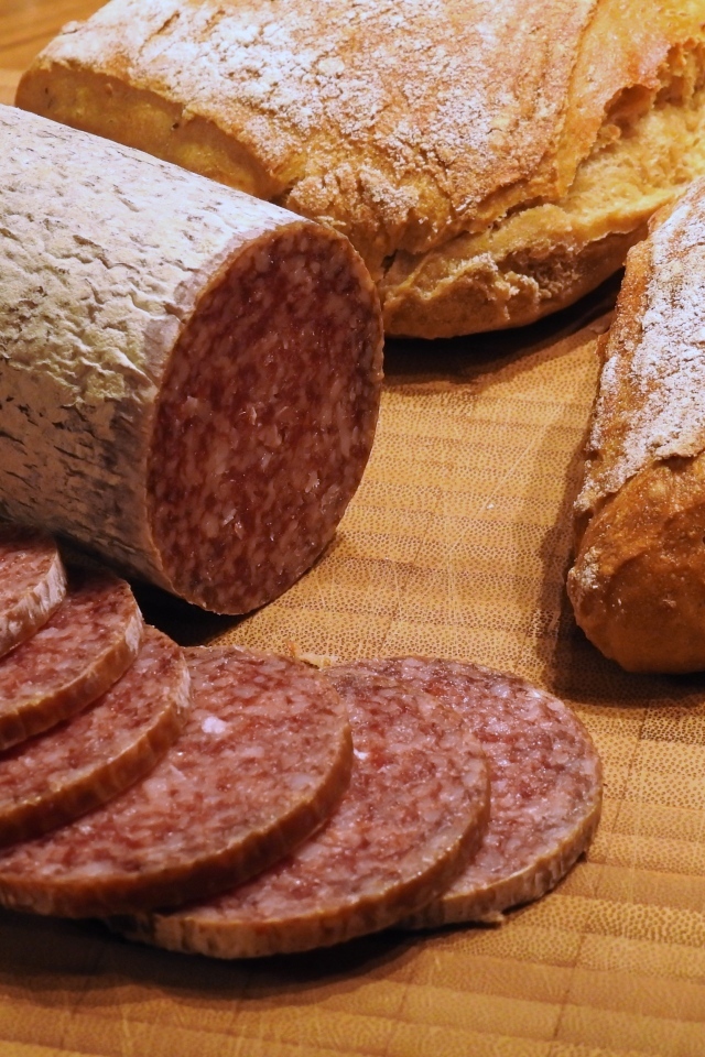 Хлеб с нарезанной колбасой на столе