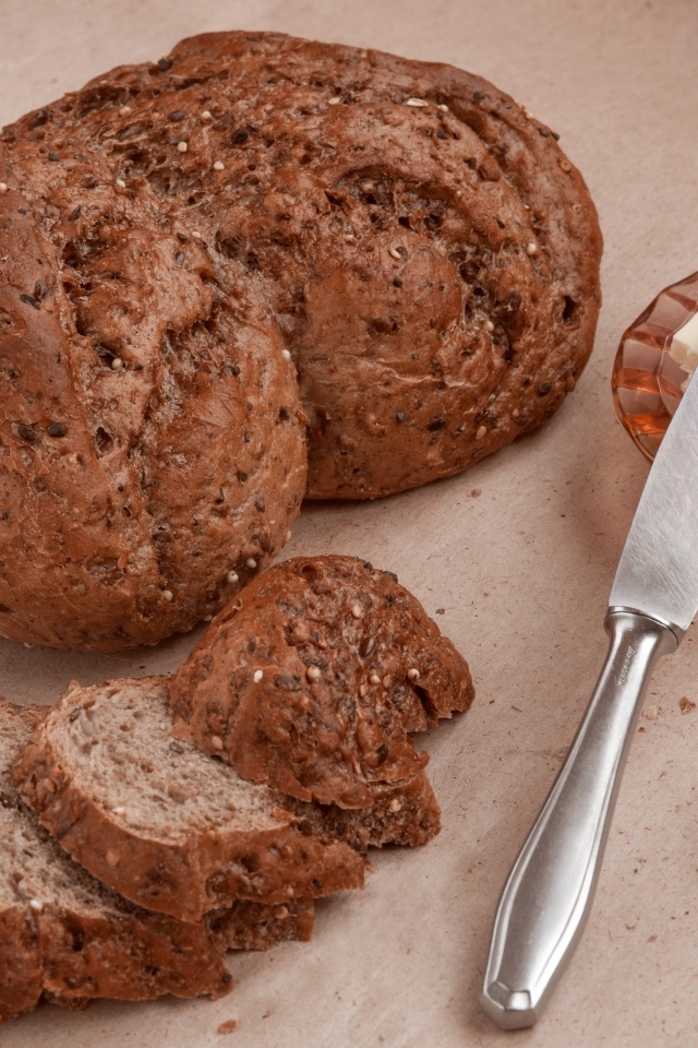 Ржаной хлеб со сливочным маслом и ножом на столе