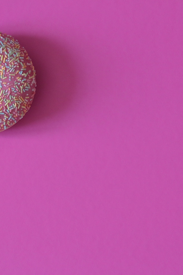 Аппетитный донат с глазурью на розовом фоне