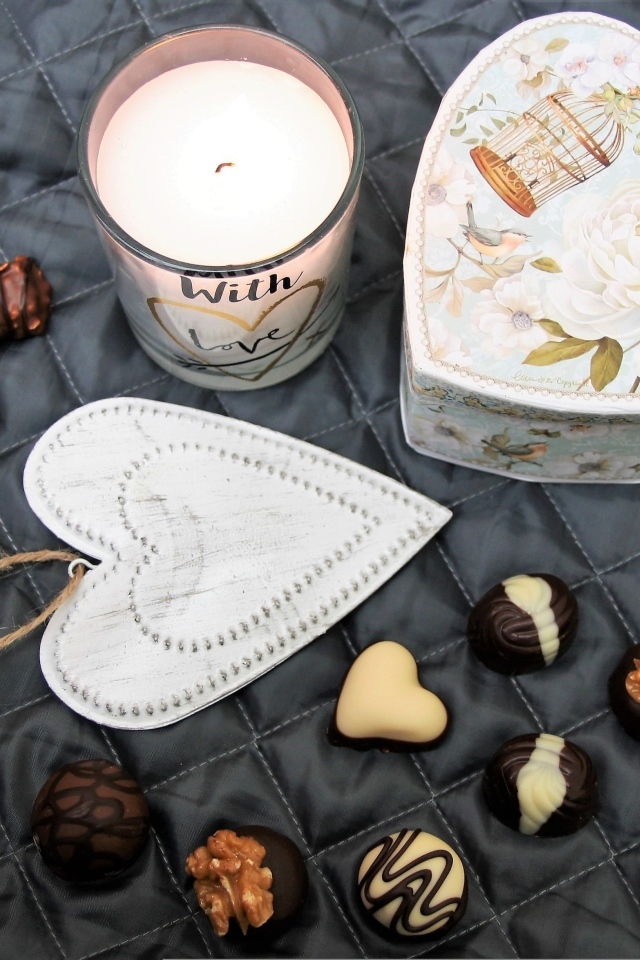 Коробка на кровати с конфетами и свечой