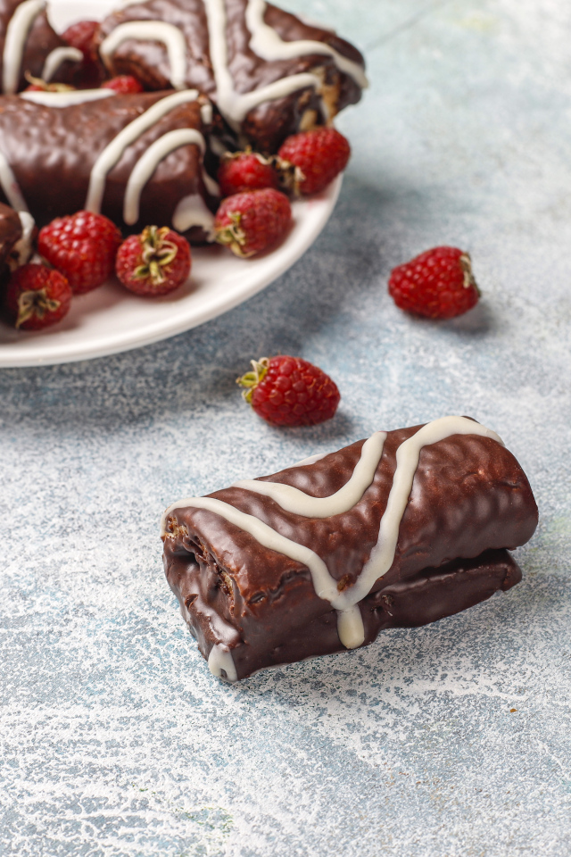 Шоколадные рулетики с ягодами малины на столе