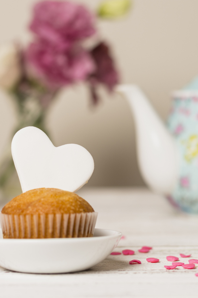 Кекс с сердечком на столе с посудой