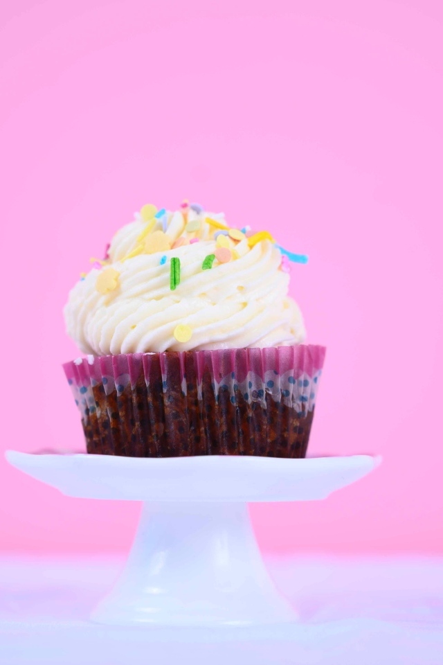 Кекс с белым кремом на розовом фоне