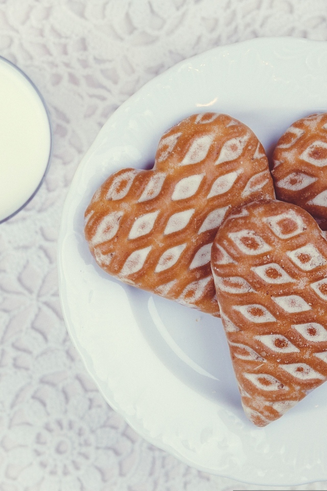 Печенье в форме сердца на столе с молоком