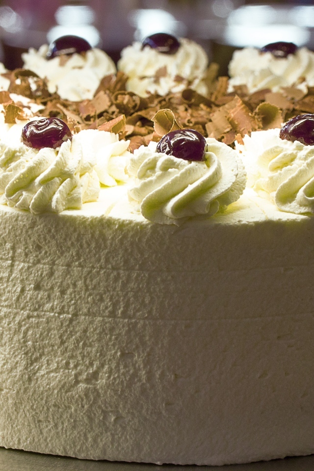 Большой белый торт с ягодами вишни