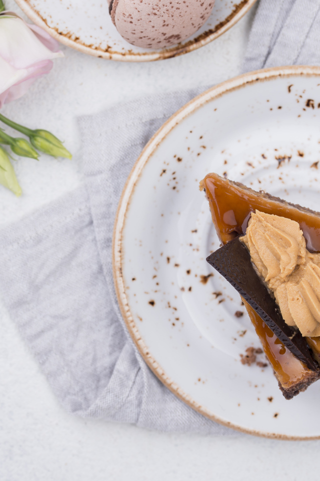 Кусок торта на тарелке на столе с цветами