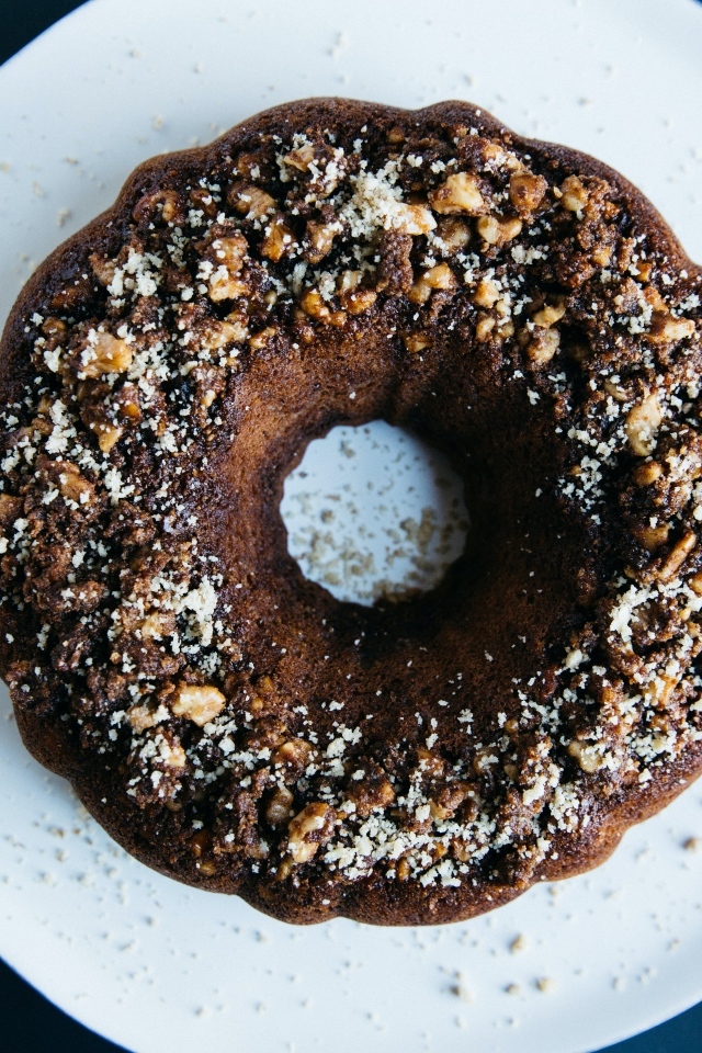 Круглый шоколадный кекс на большой белой тарелке