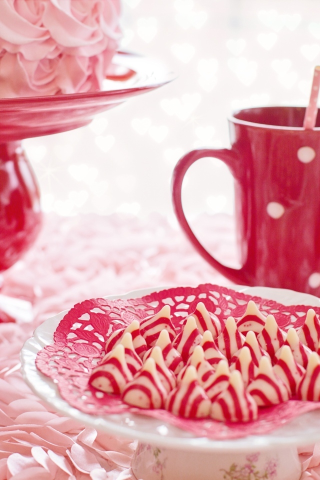 Сладкие розовые конфеты на столе с чаем и тортом